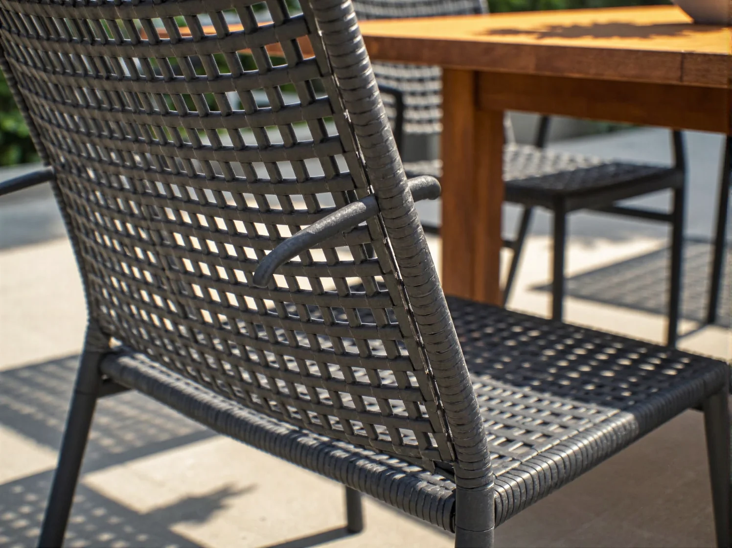 Zbliżenie na eleganckie drewniane meble ogrodowe z drewna egzotycznego, odpornego na warunki atmosferyczne.