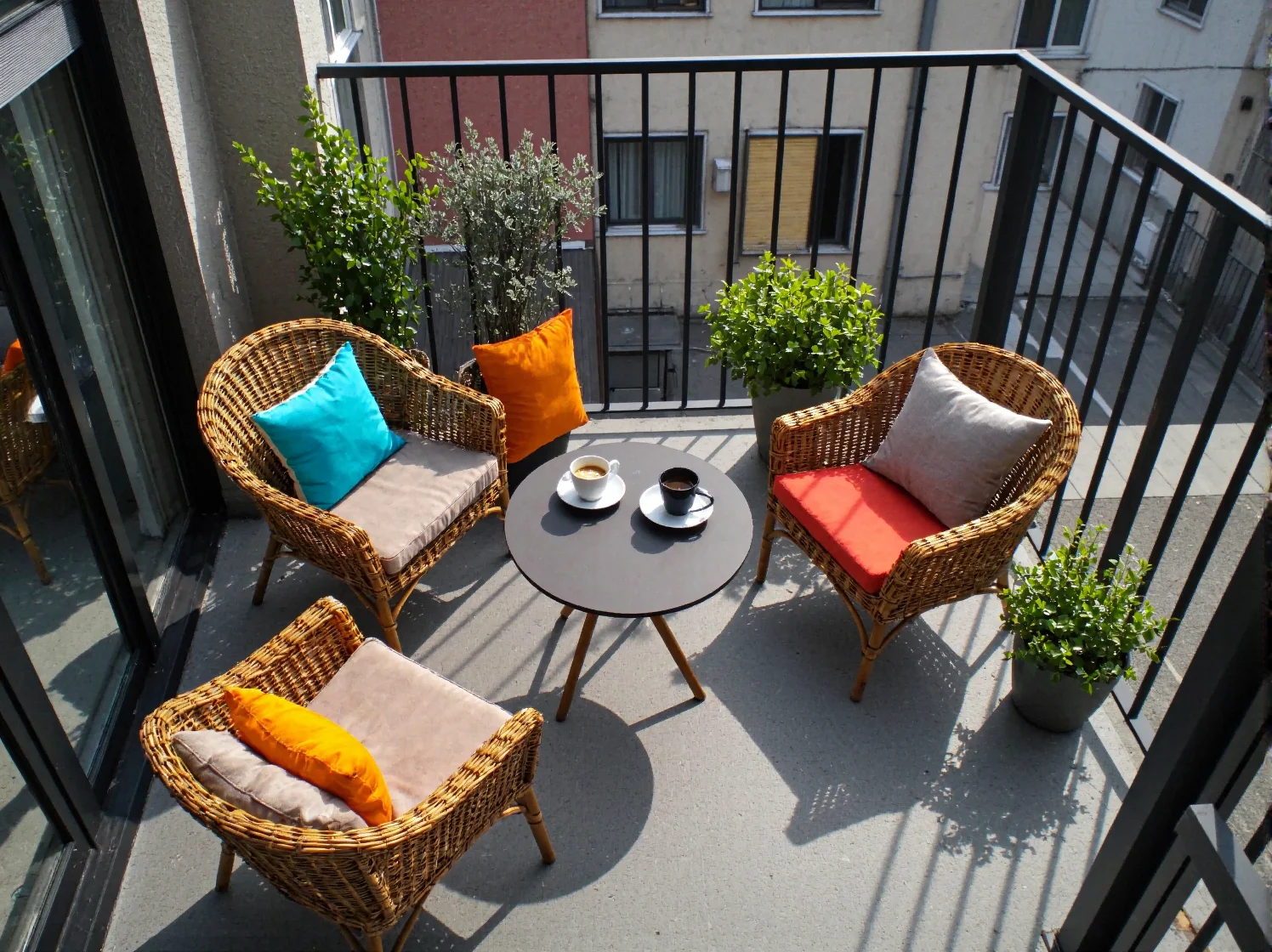 Stylowy komplet mebli ogrodowych z rattanu, odporny na warunki atmosferyczne, na nowoczesnym tarasie.